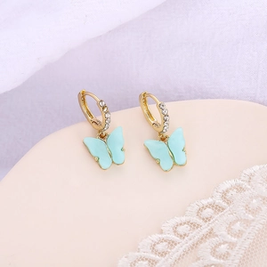 Vue détaillée des boucles d'oreilles papillon dorées avec émail bleu et cristaux