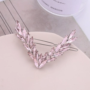 Détail d'une pince à cheveux élégante en V avec cristaux roses et motif feuille argent