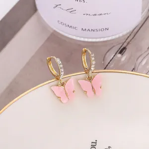 Détail de boucles d'oreilles papillon roses avec placage d'or et accents en cristal brillants