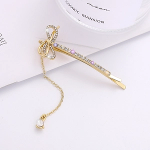 Barrette à cheveux dorée avec nœud en strass brillants et pendentif chaîne à pampille