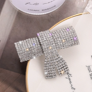 Barrette à cheveux élégante en forme de nœud avec strass brillants sur assiette déco