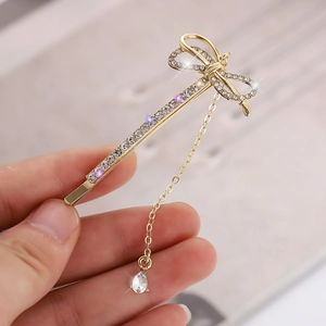 Barrette à cheveux dorée avec nœud en strass et pendentif goutte de cristal étincelant