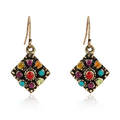 Close-up of vintage diamond-shaped hook earrings with colorful bohemian crystal stones