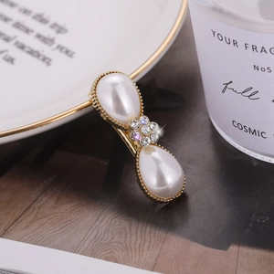 Elegant gold hair clip with large drop pearls and a delicate rhinestone flower detail