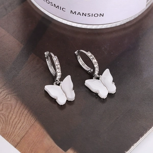 Detailed macro view of silver butterfly earrings with sparkling cubic zirconia inlay