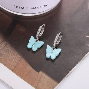 Detailed shot of light blue acrylic butterfly earrings with sparkling cubic zirconia hoops