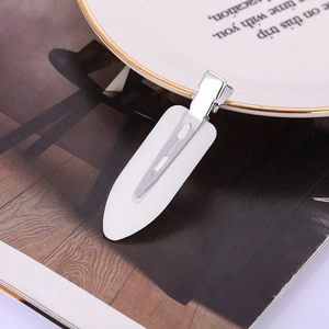 Detailaufnahme der weißen nahtlosen Haarspange auf Keramikteller für Make-up-Styling