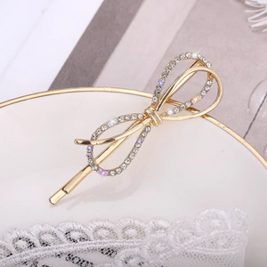 Barrette à cheveux papillon dorée avec strass scintillants sur dentelle blanche