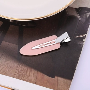 Einzelne rosa nahtlose Haarspange mit mattem Finish auf Zeitschriftenhintergrund für Styling