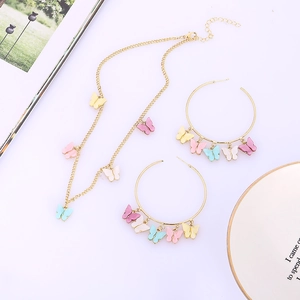 Detail van gouden ketting en oorringen set met pastelkleurige vlinder hangers