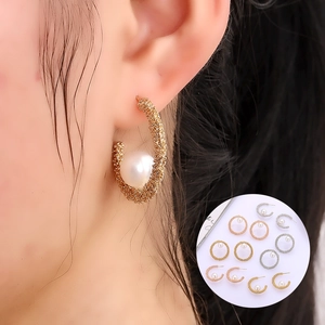 Elegant C-shaped pearl earrings with textured metal finish and large white pearls
