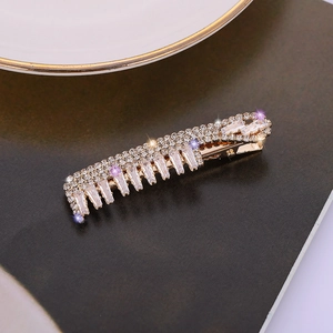 Gros plan sur une barrette en alliage doré ornée de strass blancs et de zircons étincelants