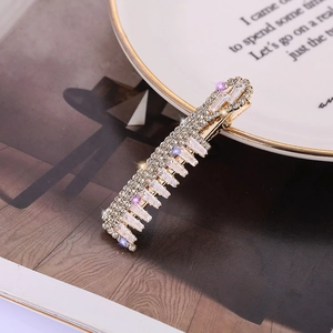 Barrette dorée élégante ornée de strass et cristaux sur céramique blanche
