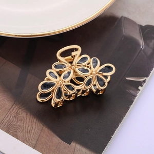 Elegant gold finish hair claw with three black hollow flower patterns for women