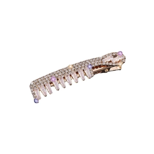 Barrette peigne dorée élégante avec cristaux brillants et gemmes mauves sur fond blanc
