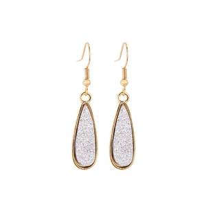 Detail of gold teardrop earrings with shimmering silver crystals in a minimalist frame