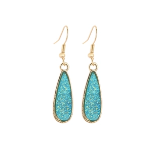 Elegant gold-plated waterdrop earrings with shimmering teal resin inlay on white background
