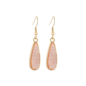 Detailed macro of pink druzy resin drop earrings with elegant gold polished edges