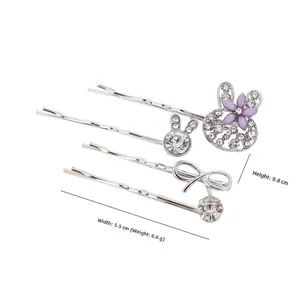 Détail d'un ensemble de 4 barrettes argentées avec des strass et des motifs de fleurs