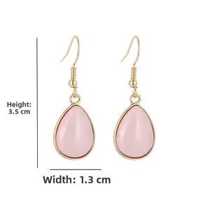 Detail van roze druppeloorbellen met gouden haken en afmetingen van 3,5 cm x 1,3 cm