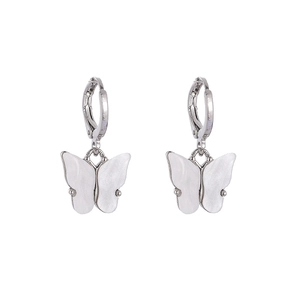Détail de boucles d'oreilles papillon blanches en acétate avec anneaux en argent