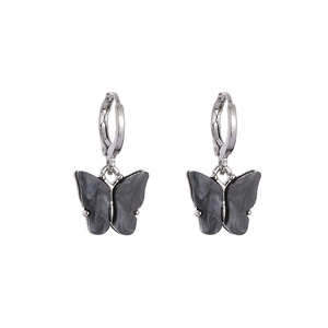 Vue détaillée des boucles d'oreilles papillon avec motif marbré gris foncé et créoles