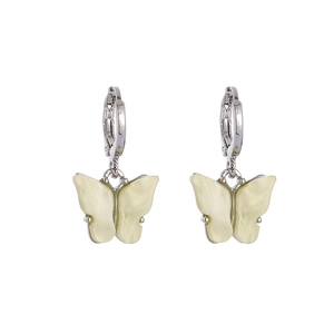Détail de boucles d'oreilles papillon crème élégantes avec créoles argentées sûres