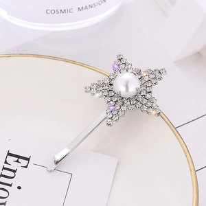 Pince à cheveux étoile argentée élégante avec strass et perle sur plateau blanc