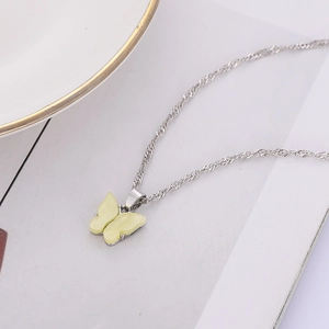 Gros plan détaillé d'un collier papillon argenté avec ailes jaunes translucides