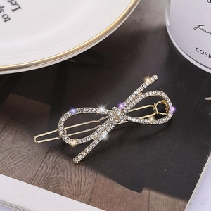 Barrette à cheveux dorée avec strass brillants sur un fond de magazine sombre