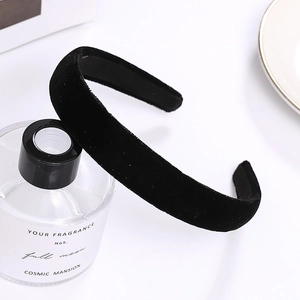 Serre-tête minimaliste en velours noir pour femme présenté sur un flacon en verre