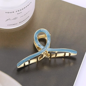 Elegant gold metal cross hair claw clip with blue marble pattern inlay for women