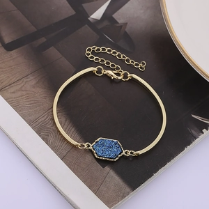 Detail of gold bracelet with hexagonal blue crystal and adjustable lobster clasp