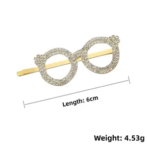 Détail de la pince à cheveux dorée en forme de lunettes avec strass blancs étincelants