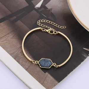 Detail of gold hexagon crystal bracelet featuring blue resin stone and adjustable clasp