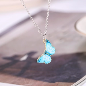 Detail of blue gradient butterfly pendant with gold-edged wings and silver chain