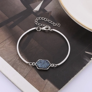 Detailed close-up of a silver-toned bracelet featuring a hexagonal deep blue resin stone