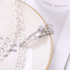 Elegante pinza para el cabello de mariposa plateada con diamantes en plato blanco
