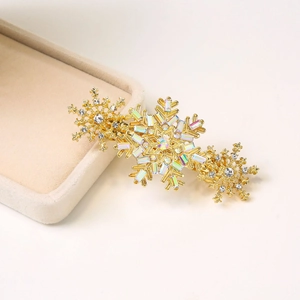 Barrette à cheveux flocon de neige dorée avec strass brillants sur boîte à bijoux velours