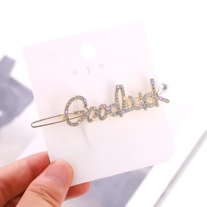Détail macro de la barrette Goodluck avec strass étincelants et finition dorée