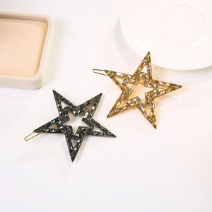 Dettaglio di fermagli per capelli a forma di stella con strass in oro e canna di fucile