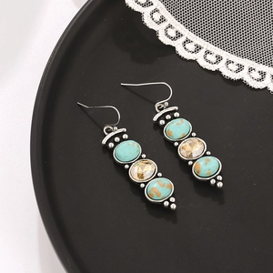 Macro detail of vintage silver drop earrings with turquoise and champagne crystals