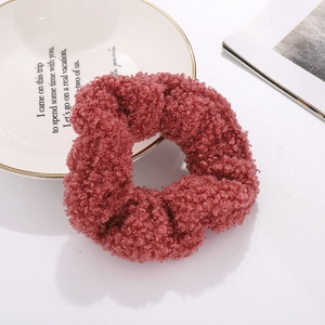 Plush teddy fleece scrunchie in dusty pink color on elegant white ceramic plate