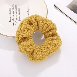 Detail of ginger teddy velvet scrunchie showing soft lamb wool texture on a white table