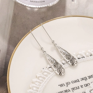 Silver teardrop hollow engraved earrings with Celtic pattern on a vintage plate