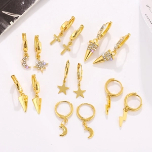 Flat lay of gold plated drop earring set with crystal moon star and cross charms