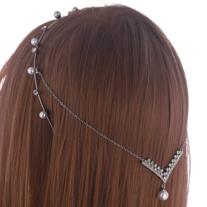 Elegant pearl and rhinestone hair chain accessory worn on long brown hair from behind