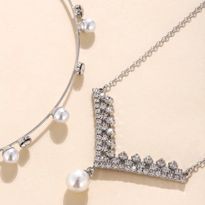 Elegant silver V-shaped necklace and pearl headpiece set with sparkling crystals