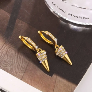 Detail of gold-plated hoop earrings with crystal-encrusted spikes and punk style
