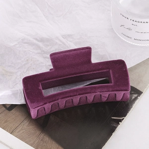 Macro shot of large burgundy flocked rectangular claw clip on a lifestyle magazine background